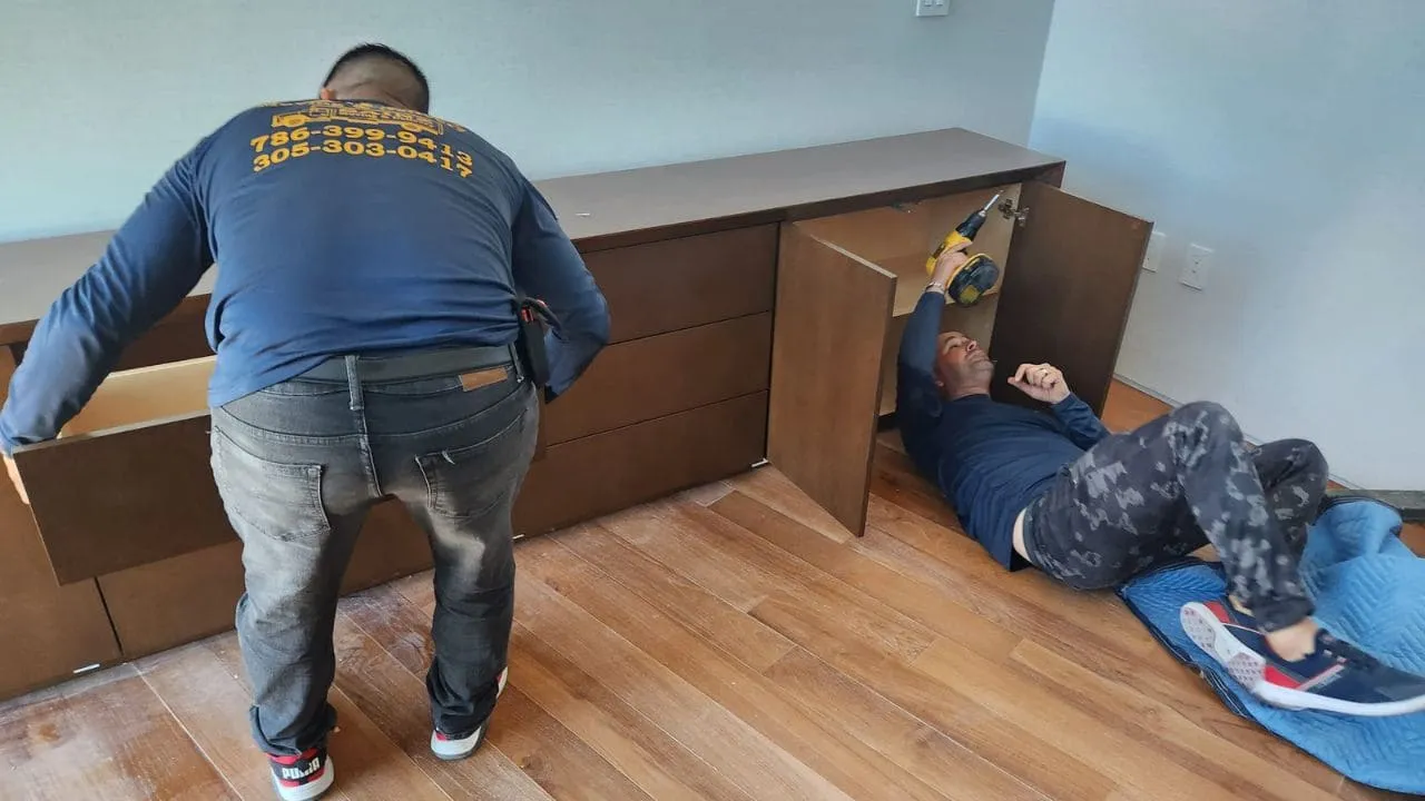Sainz Moving crew member in company shirt assembling furniture indoors