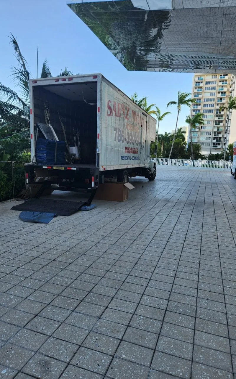 Sainz Moving truck with open rear at a waterfront building
