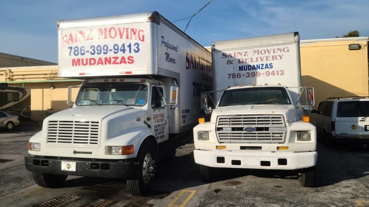 Two Sainz Moving trucks parked side by side